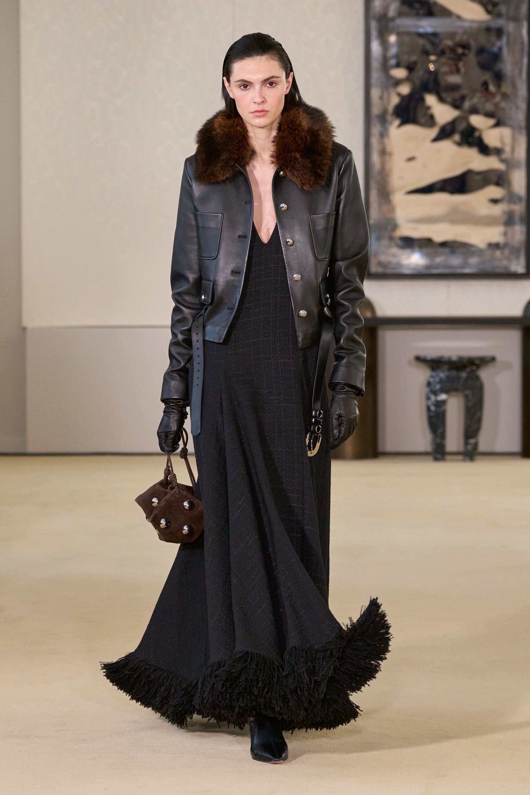 Altuzarra以克制而精准的剪裁回应都市女性的力量命题，皮革长裙、毛领外套与细节扣饰勾勒冷静轮廓，在黑棕与灰调之间展现成熟而富有策略性的优雅，将性感与权威融为一体-顽石频道趋势研究